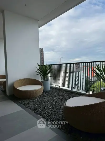 Spacious balcony with modern seating and city view, perfect for relaxation and entertaining.