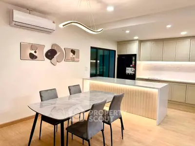 Modern kitchen and dining area with sleek design and stylish lighting.