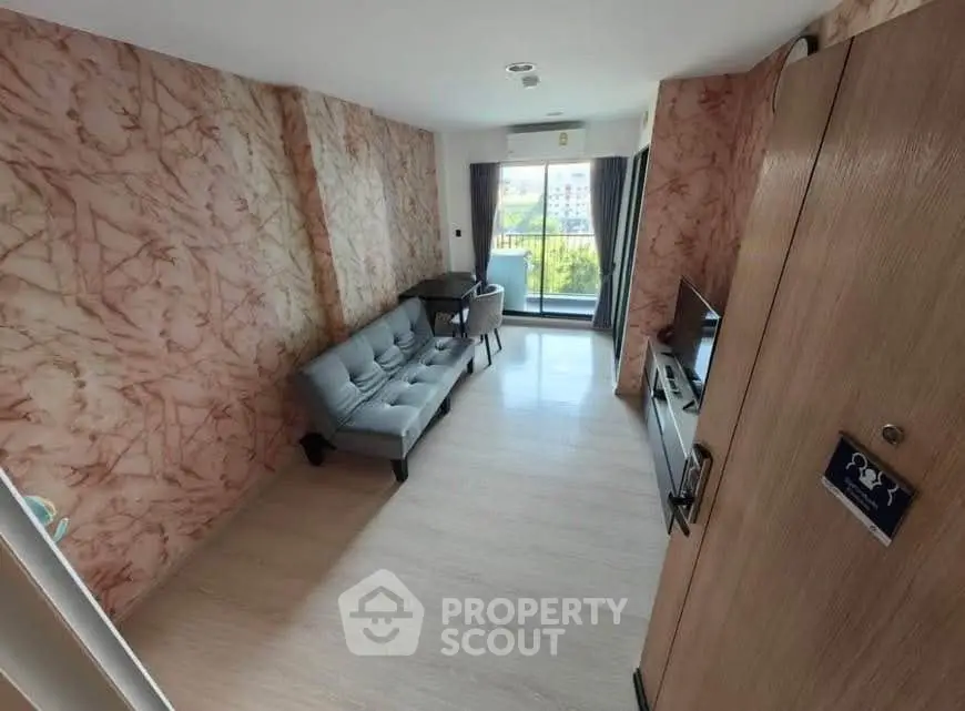 Stylish living room with modern decor and large window offering natural light and scenic view.