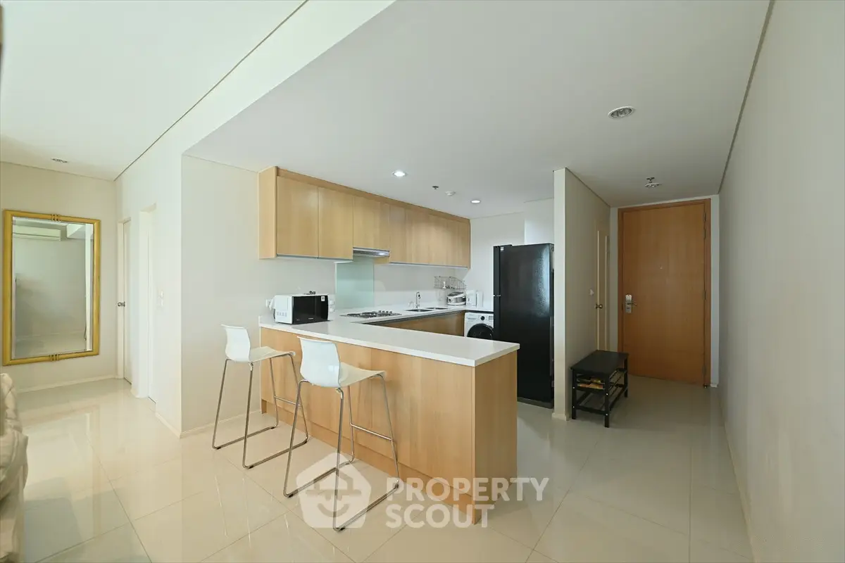 Modern kitchen with sleek design and open layout, featuring a breakfast bar and contemporary appliances.