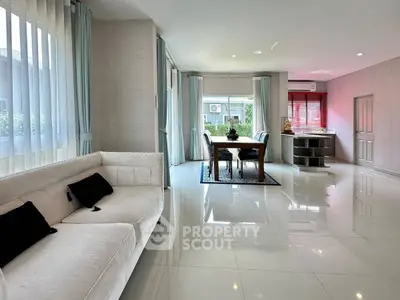 Spacious modern living room with elegant dining area and large windows.