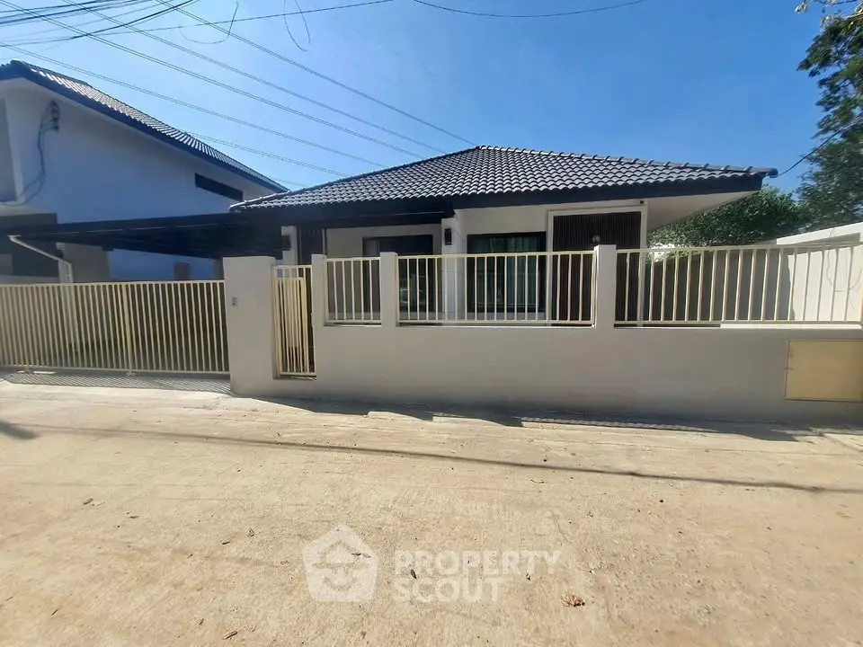 Charming single-story home with modern fence and tiled roof in a serene neighborhood.