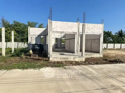 Unfinished concrete structure on a spacious plot, ideal for custom home building.