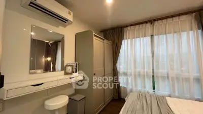 Cozy bedroom with modern decor, featuring a large window and ample storage space.