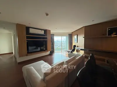 Spacious living room with modern decor and city view balcony in luxury apartment.