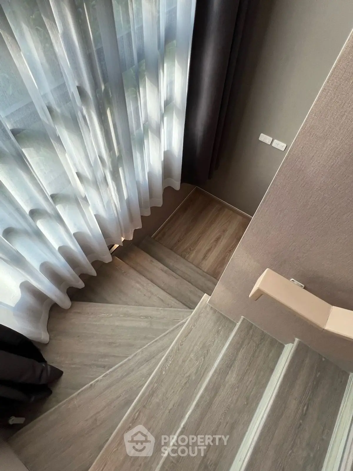 Elegant staircase with modern design and floor-to-ceiling curtains