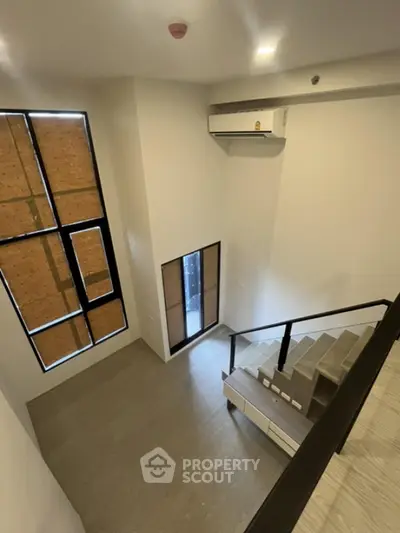 Modern loft-style interior with high ceilings and large windows