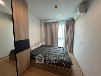 Modern bedroom with sleek design, featuring a cozy bed and ample natural light through large window.