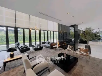 Luxurious modern living room with elegant furniture and large windows offering garden views.