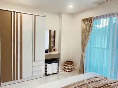 Modern bedroom with sleek wardrobe and elegant curtains, perfect for a cozy living space.