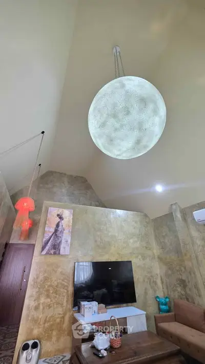 Spacious living room with high ceiling and unique spherical chandelier