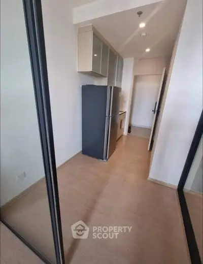 Modern kitchen with sleek design and spacious layout, featuring a large fridge and ample storage.