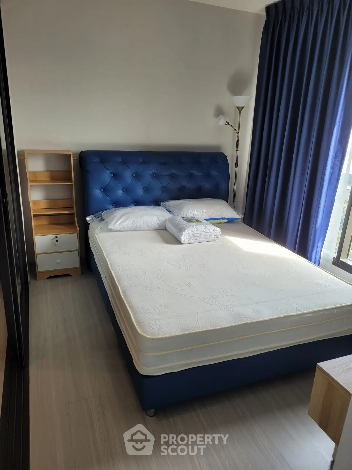 Modern bedroom with blue upholstered bed and natural light