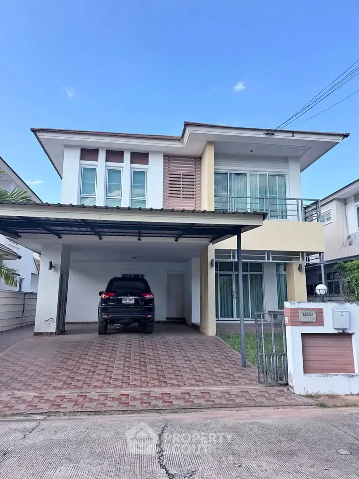 Modern two-story house with carport and sleek exterior design in a suburban neighborhood.