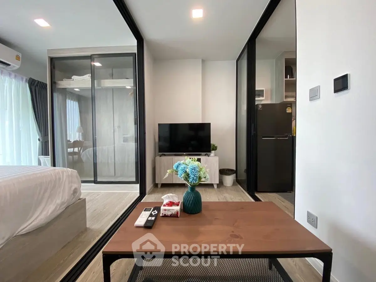 Modern living room with glass partitions and sleek furniture in a stylish apartment.