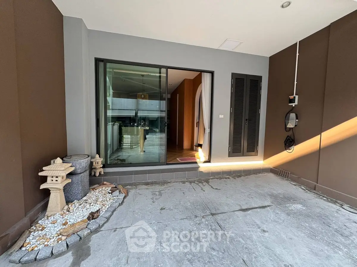 Modern entrance with stone decor and sliding glass door in a stylish home.