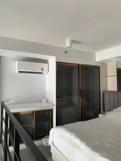 Modern bedroom with sleek design and air conditioning in a stylish apartment.