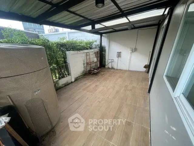 Spacious covered balcony with tiled flooring and garden view