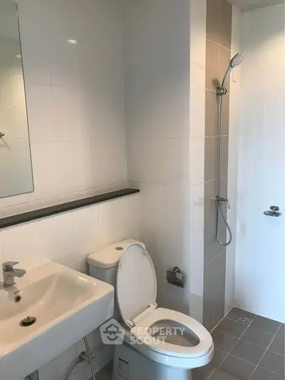 Modern bathroom with sleek fixtures and minimalist design, featuring a shower and toilet.