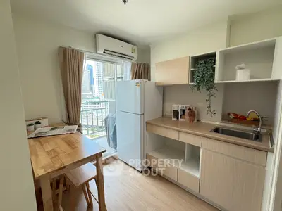 Modern kitchen with open layout and balcony view in city apartment