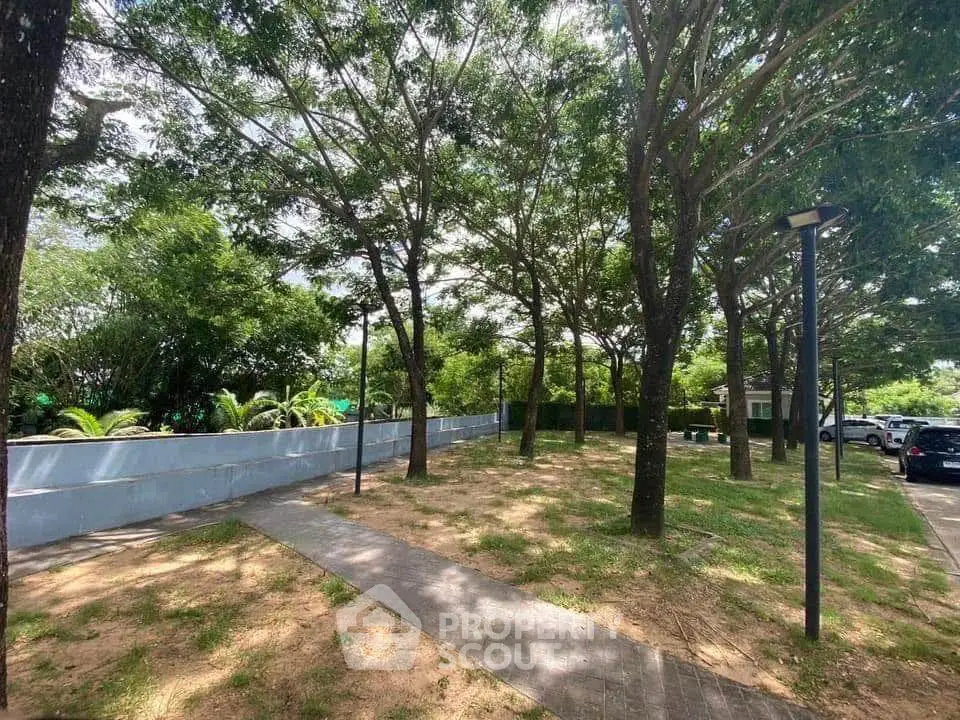 Serene garden area with lush trees and pathway in residential community.