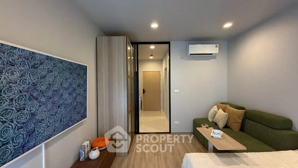 Modern living room with green sofa, air conditioning, and stylish decor