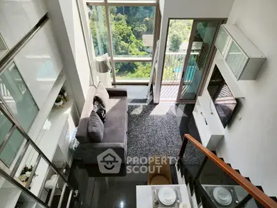 Stunning loft apartment with floor-to-ceiling windows and lush green views