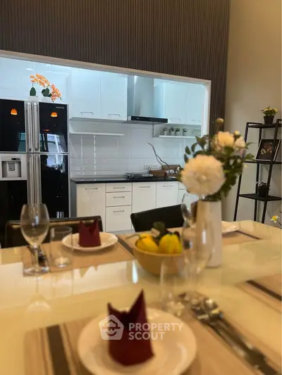 Modern kitchen with sleek appliances and elegant dining setup, perfect for contemporary living.