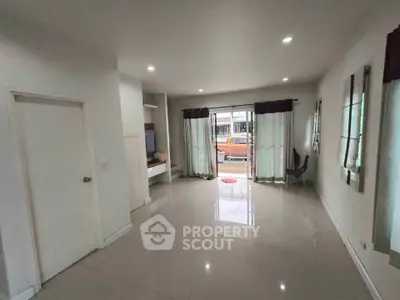 Spacious living room with large windows and modern decor, perfect for family gatherings.