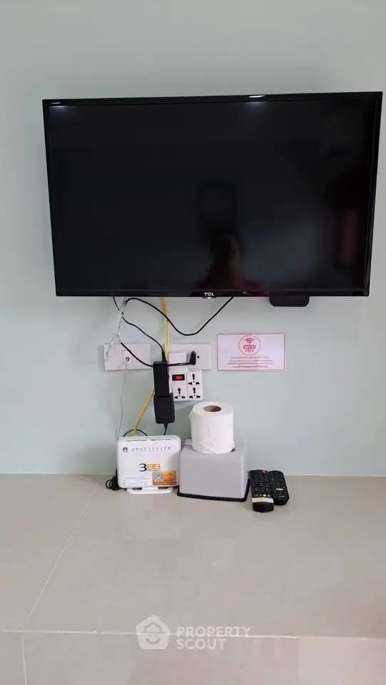 Modern living room with wall-mounted TV and sleek entertainment setup.