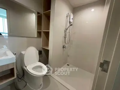 Modern bathroom with sleek shower and toilet in contemporary apartment.