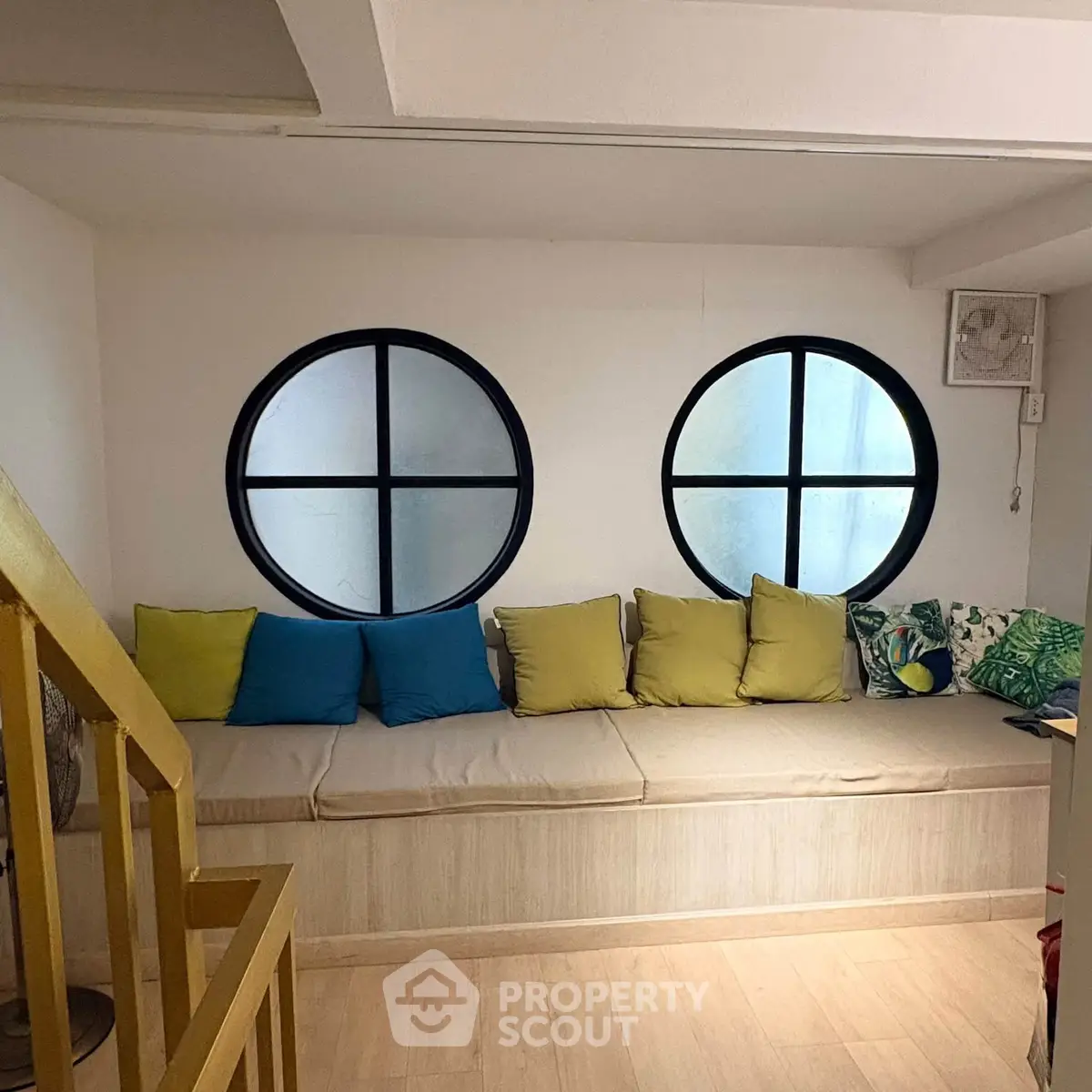 Charming living room with unique round windows and cozy seating area, perfect for relaxation.