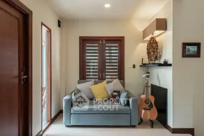 Cozy living room with stylish decor and natural light, featuring a comfortable sofa and guitar.
