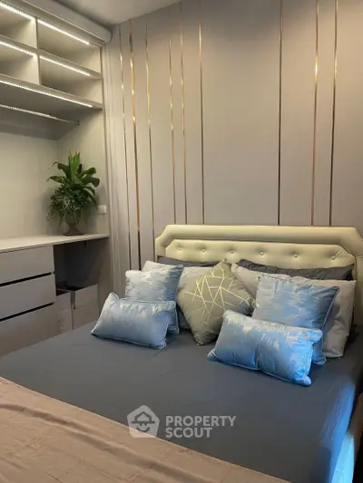 Elegant bedroom with modern decor and plush pillows, featuring built-in storage and ambient lighting.