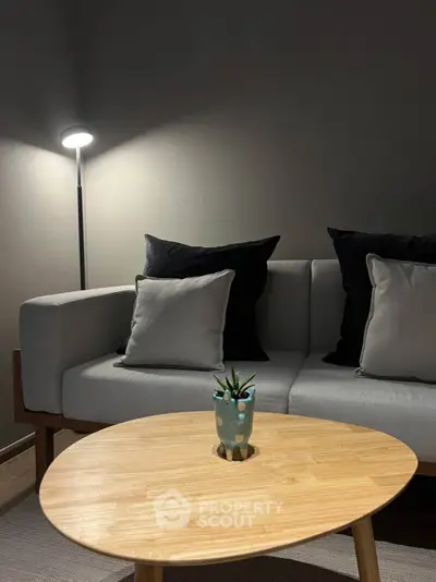 Modern living room with stylish gray sofa and wooden coffee table, perfect for cozy evenings.