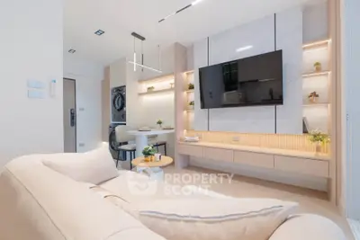 Modern living room with sleek design, featuring a wall-mounted TV and elegant lighting.