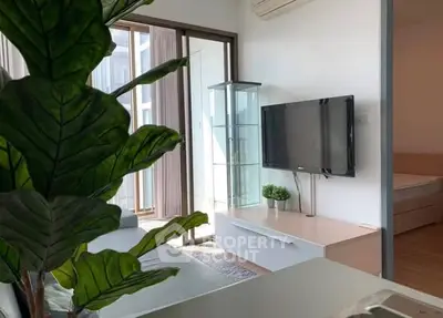Modern living room with TV and glass cabinet, featuring a cozy bedroom view.