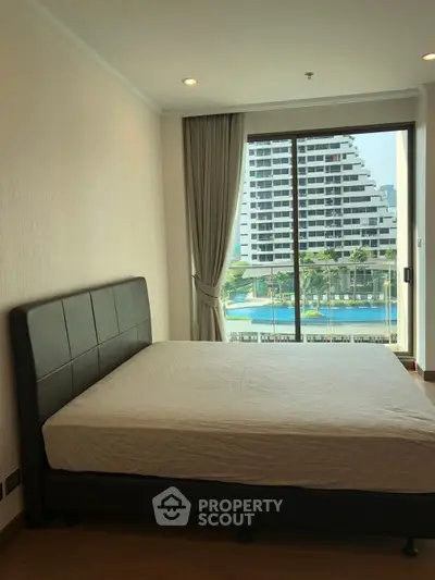 Modern bedroom with pool view and large window in luxury apartment