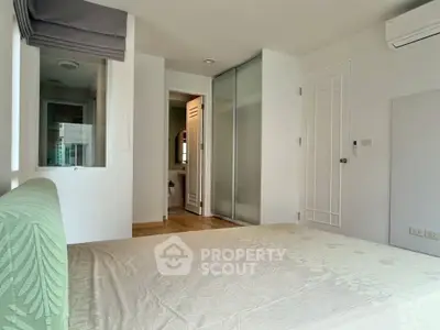 Spacious bedroom with modern design and ensuite bathroom in a stylish apartment.