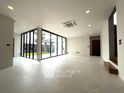 Spacious modern living room with large windows and garden view