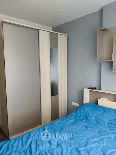 Modern bedroom with sleek wardrobe and cozy blue bedding