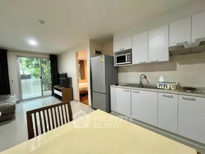 Modern open-layout kitchen with dining area and view of living room and bedroom