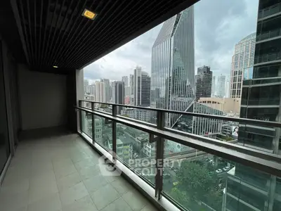 Spacious balcony with stunning city skyline view in modern high-rise building.