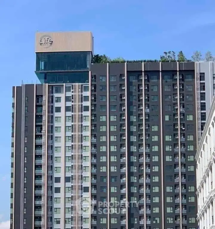 Modern high-rise building with sleek design and rooftop greenery, ideal for urban living.