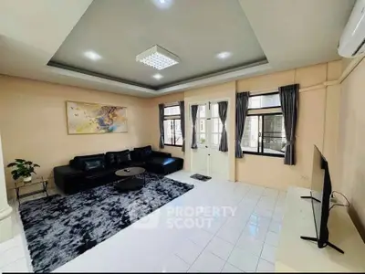 Spacious living room with modern decor and large windows in a stylish apartment.