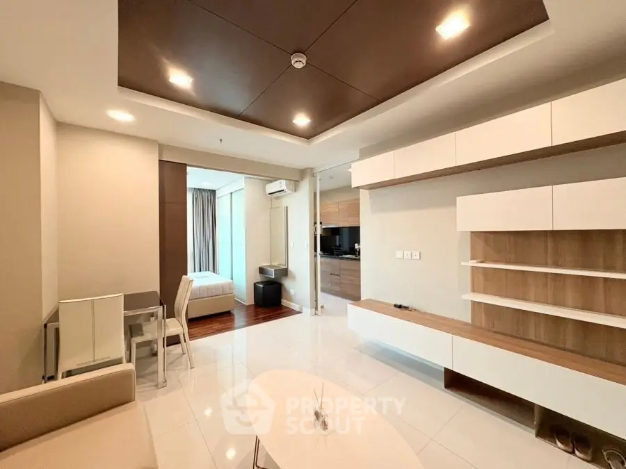 Modern open-plan living room with sleek furniture and stylish ceiling design.