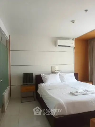 Modern bedroom with sleek design, featuring a comfortable bed, air conditioning, and minimalist decor.
