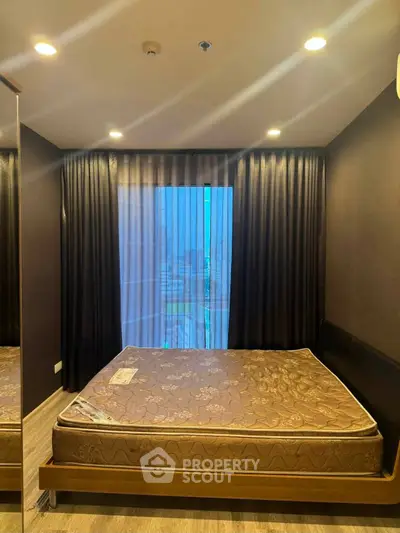 Modern bedroom with large window and stylish curtains in a cozy apartment.