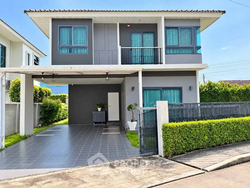 Modern two-story house with sleek design and spacious driveway in a suburban neighborhood.