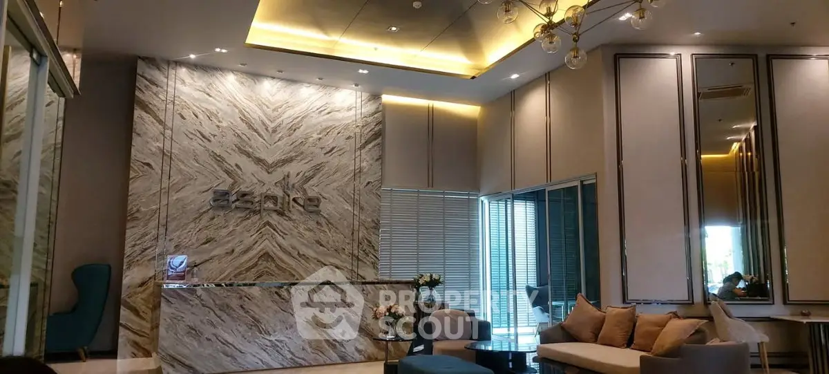 Luxurious modern lobby with elegant marble walls and stylish seating area in upscale building.